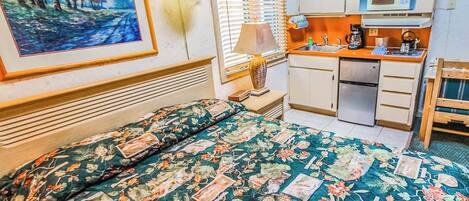 Une chambre d’hôtel équipée d’un lit, d’un bureau, d’un four à micro-ondes et d’un lavabo.