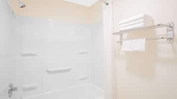 A modern bathroom with a bathtub, a shower, and a towel rack.
