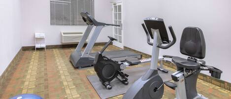 A gym with treadmills, an elliptical, and a stationary bike.