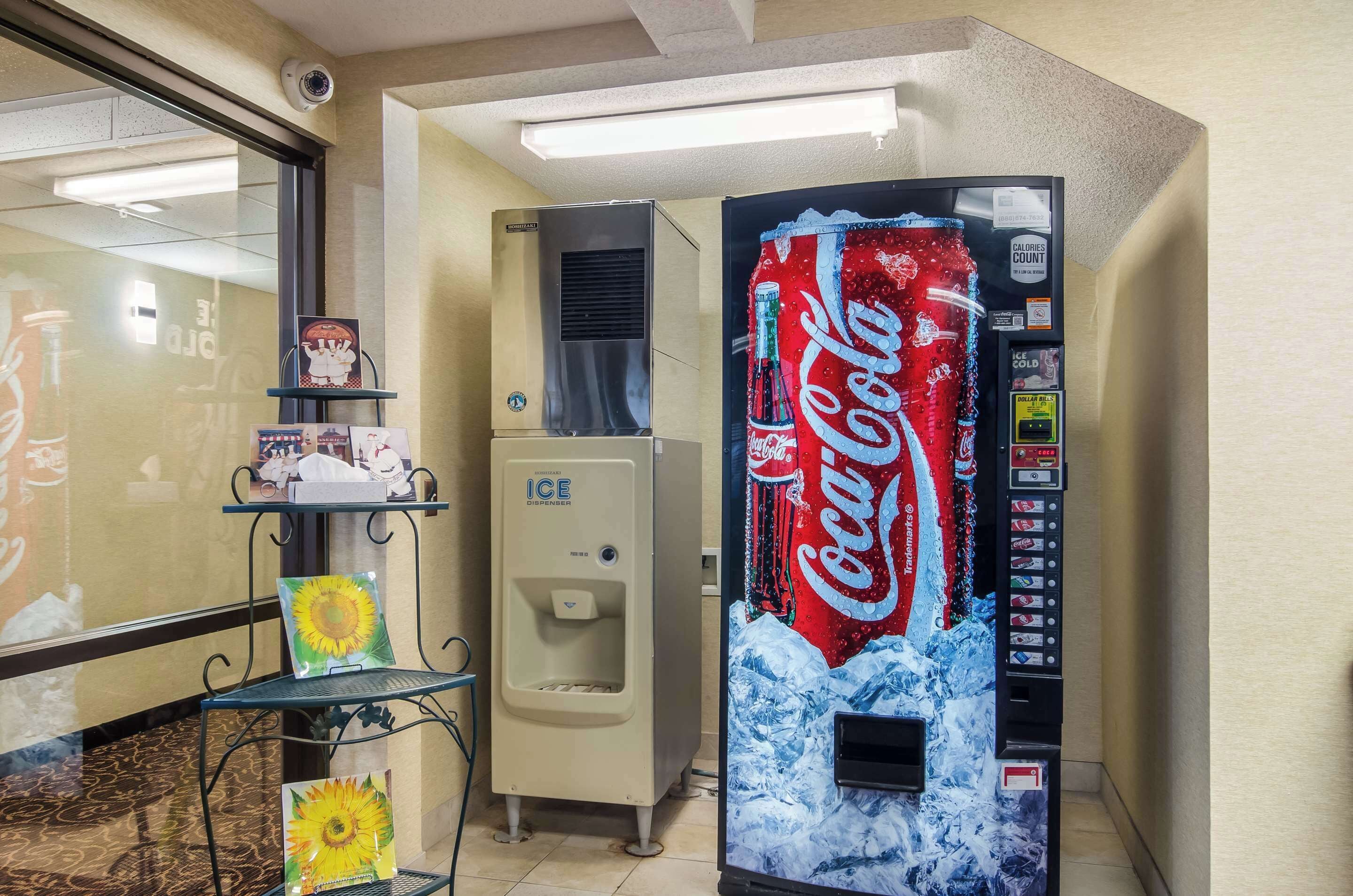 Een automaat met Coca-Cola reclame, een ijsdispenser en een klein schap met producten.