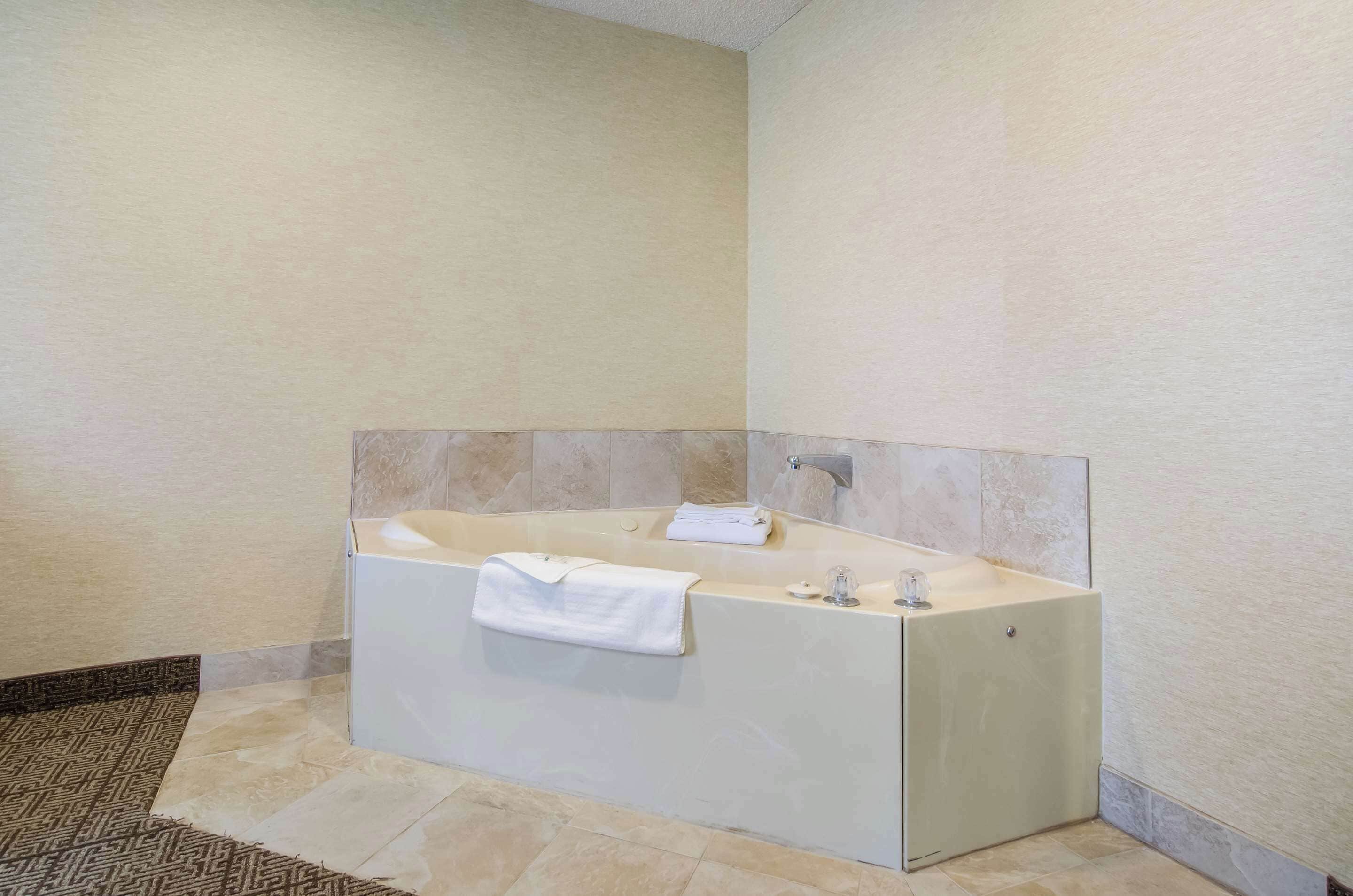 Un baño moderno con una bañera independiente, una toalla y un espejo.