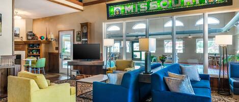 A spacious living area with a large TV, comfortable seating, and a sign reading "MISSOURI".