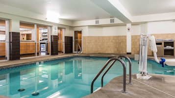 Una piscina techada, sillones reclinables de piscina