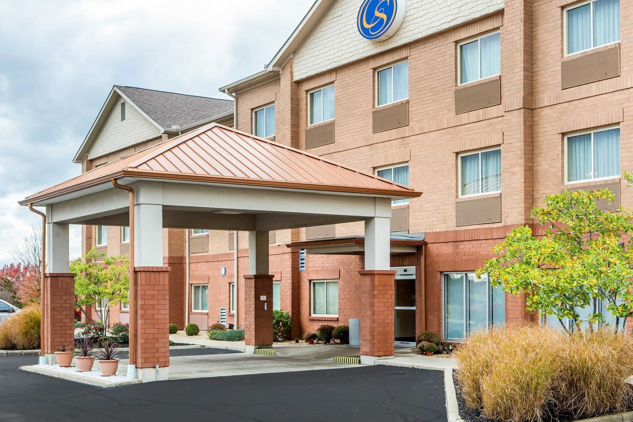 A hotel with a covered entrance, multiple windows, and a sign with a wheelchair symbol.