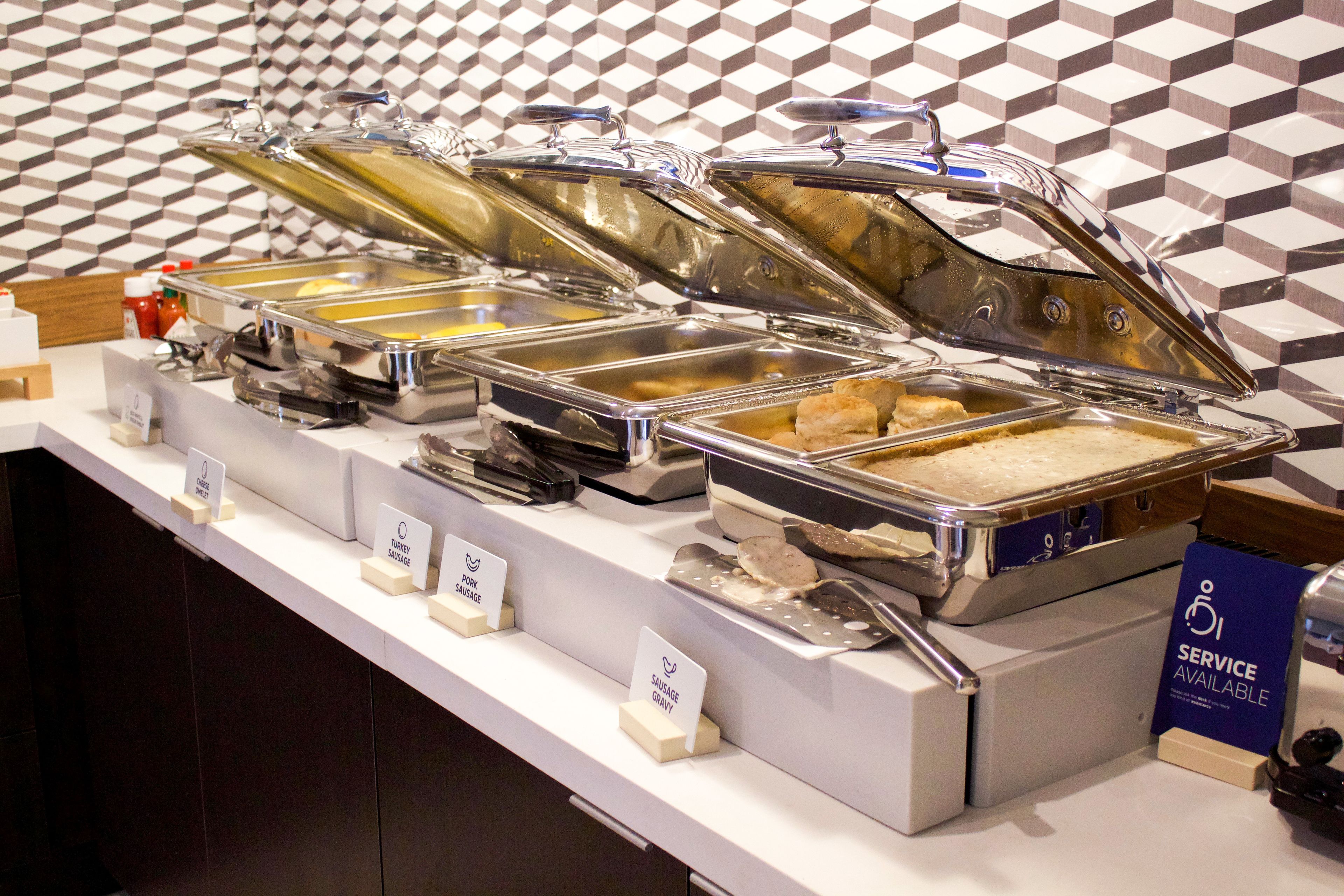A buffet with labeled containers for turkey sausage, pork sausage, and sausage gravy.