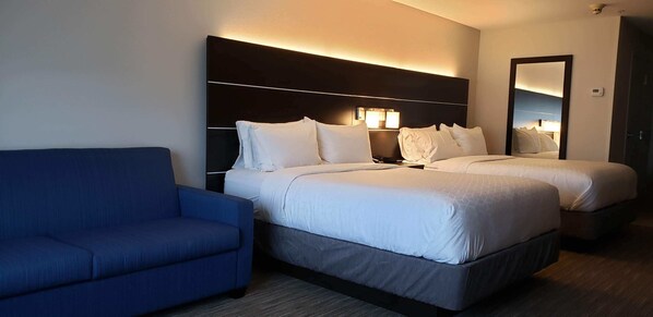 A hotel room with a large bed, a smaller bed, a blue sofa, and a wall-mounted mirror. - Holiday Inn Express & Suites Hood River by IHG (Hood River)