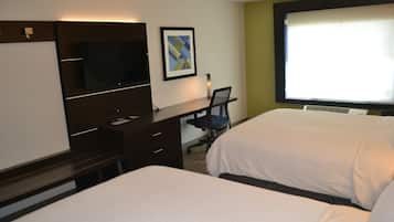 A hotel room with two beds, a desk with a chair, a television, and a framed picture on the wall.