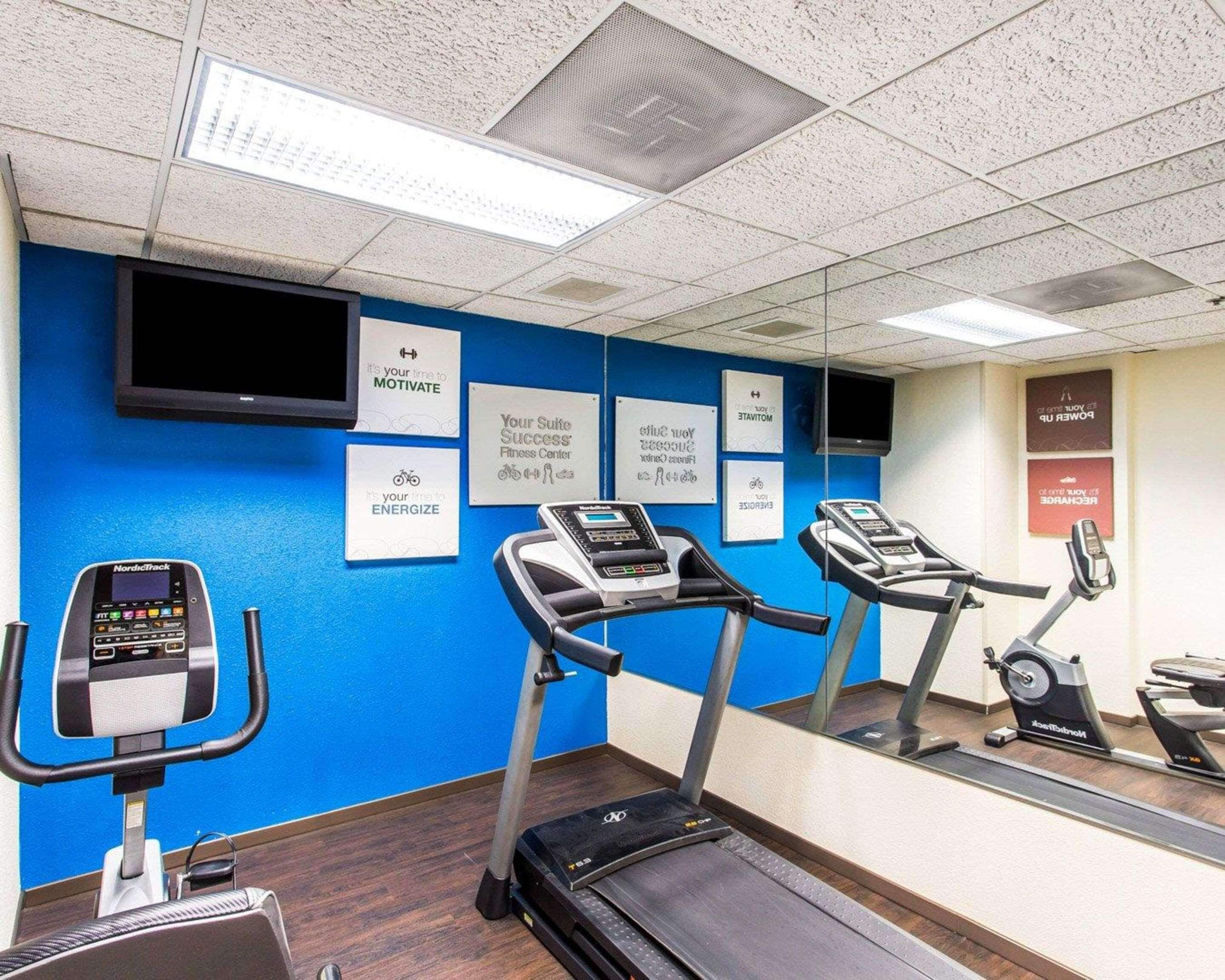 A fitness center with treadmills, a NordicTrack, and motivational posters on the walls.