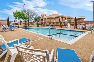 Una piscina al aire libre de temporada, tumbonas