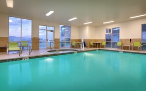 An indoor swimming pool with chairs and tables, large windows, and a view of the outdoors. - Holiday Inn Express & Suites American Fork - North Provo by IHG (American Fork)