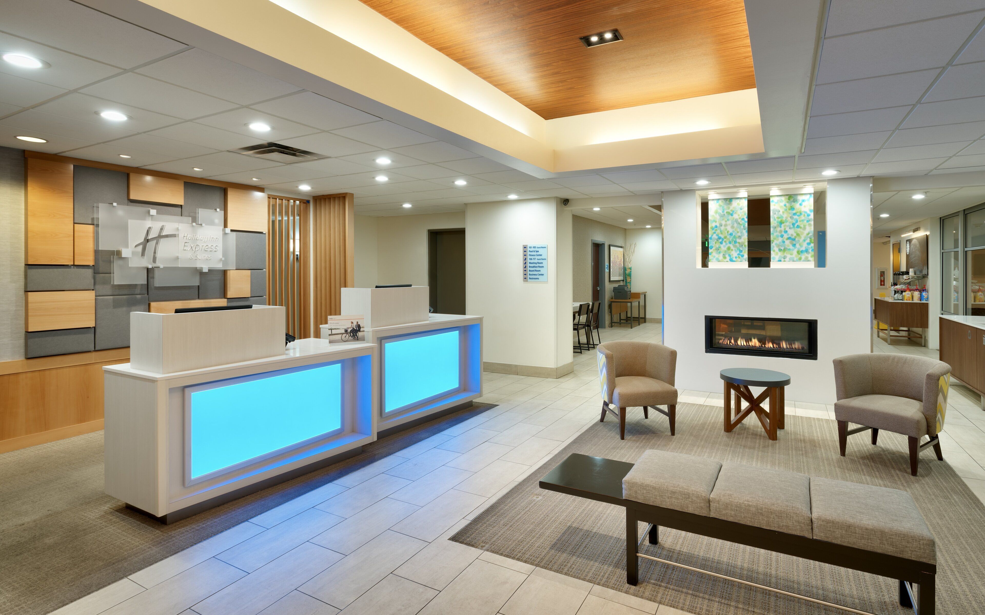 A hotel reception area with a reception desk, seating area, and a fireplace.