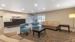 A lobby with a reception desk, seating area, and a patterned carpet.