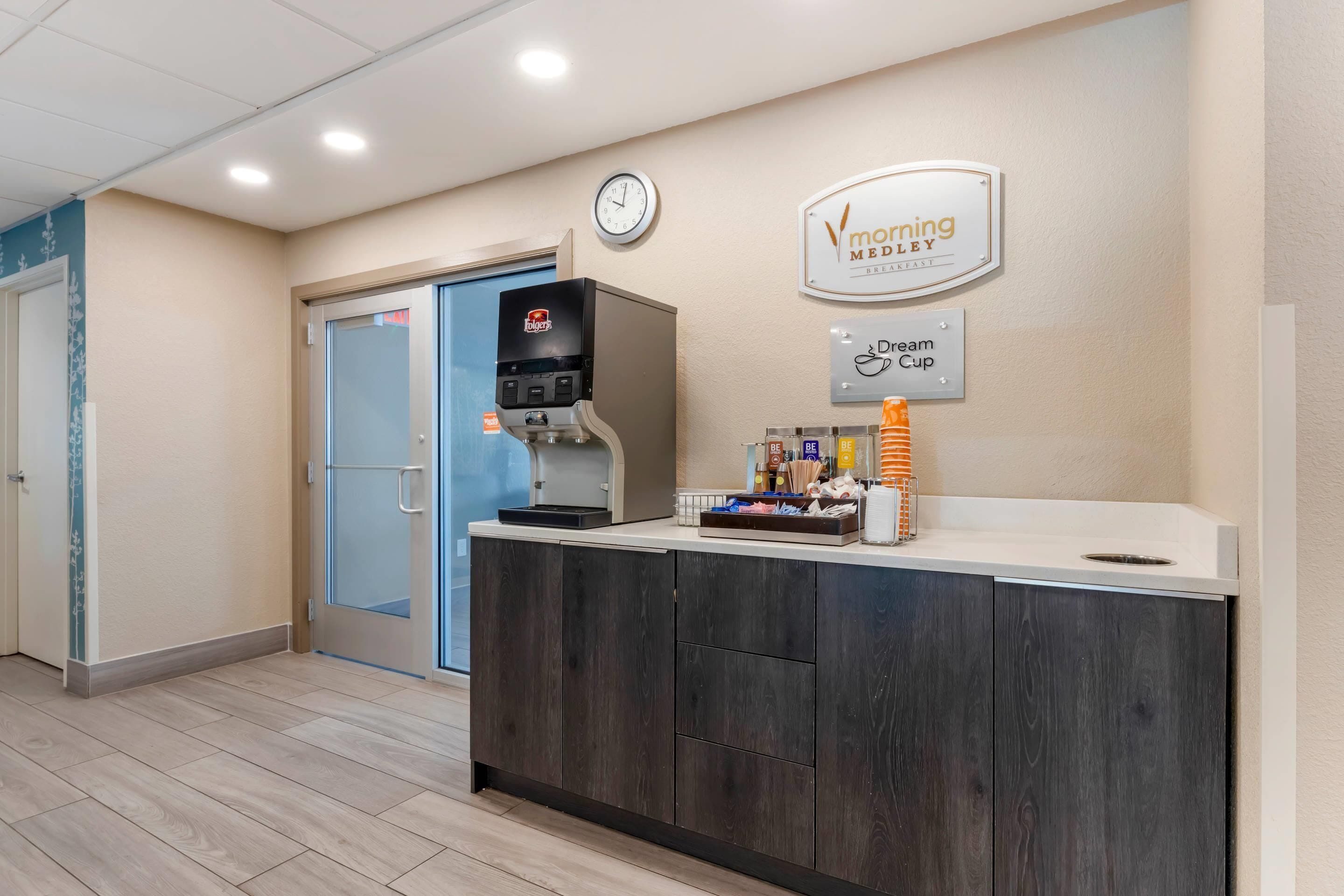 A reception area with a coffee machine, a clock, and a sign for 'Morning Meadow' and 'Dream Cup'.