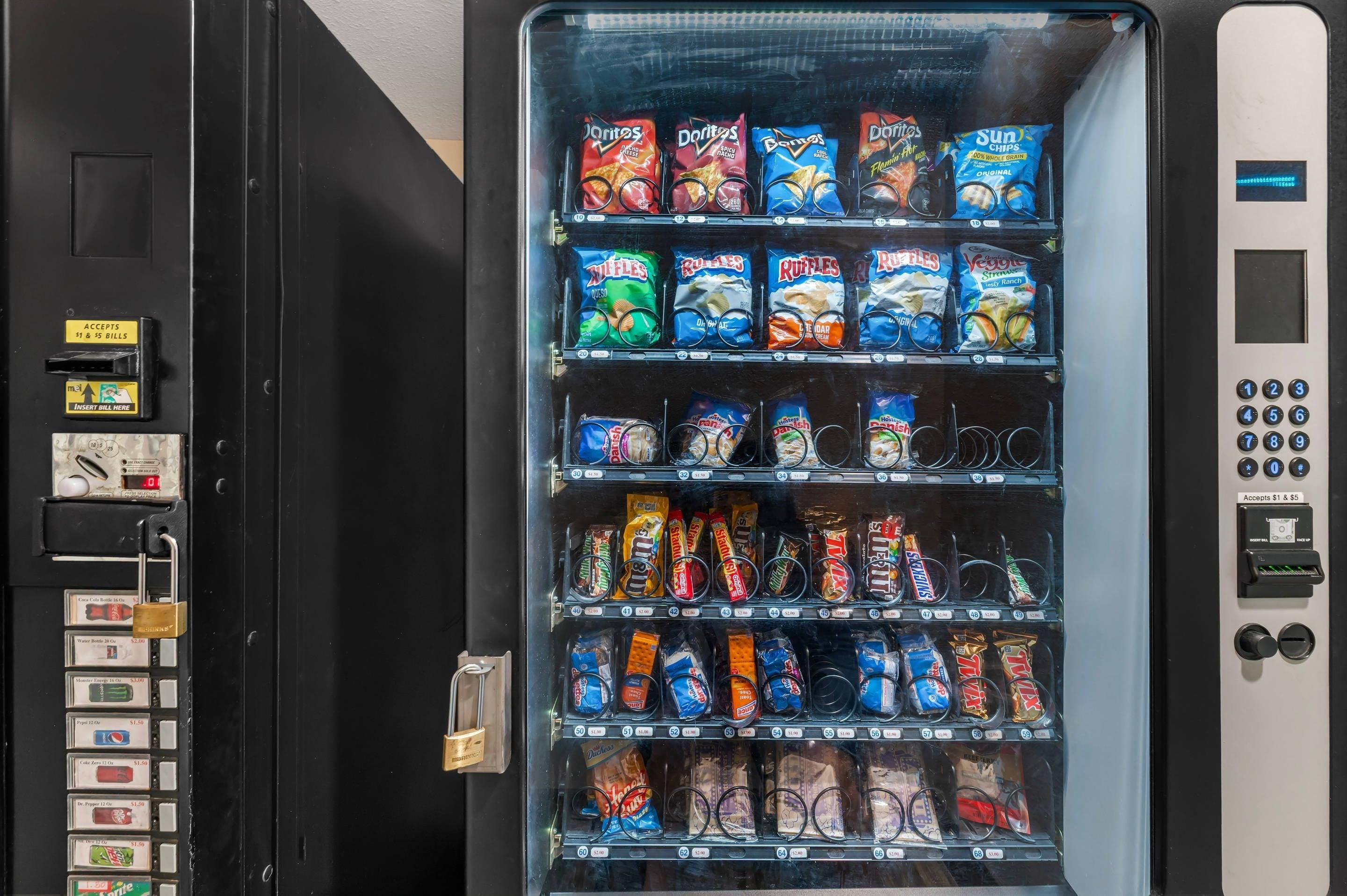 A vending machine with various snacks and drinks, including chips, cookies, and bottled water.
