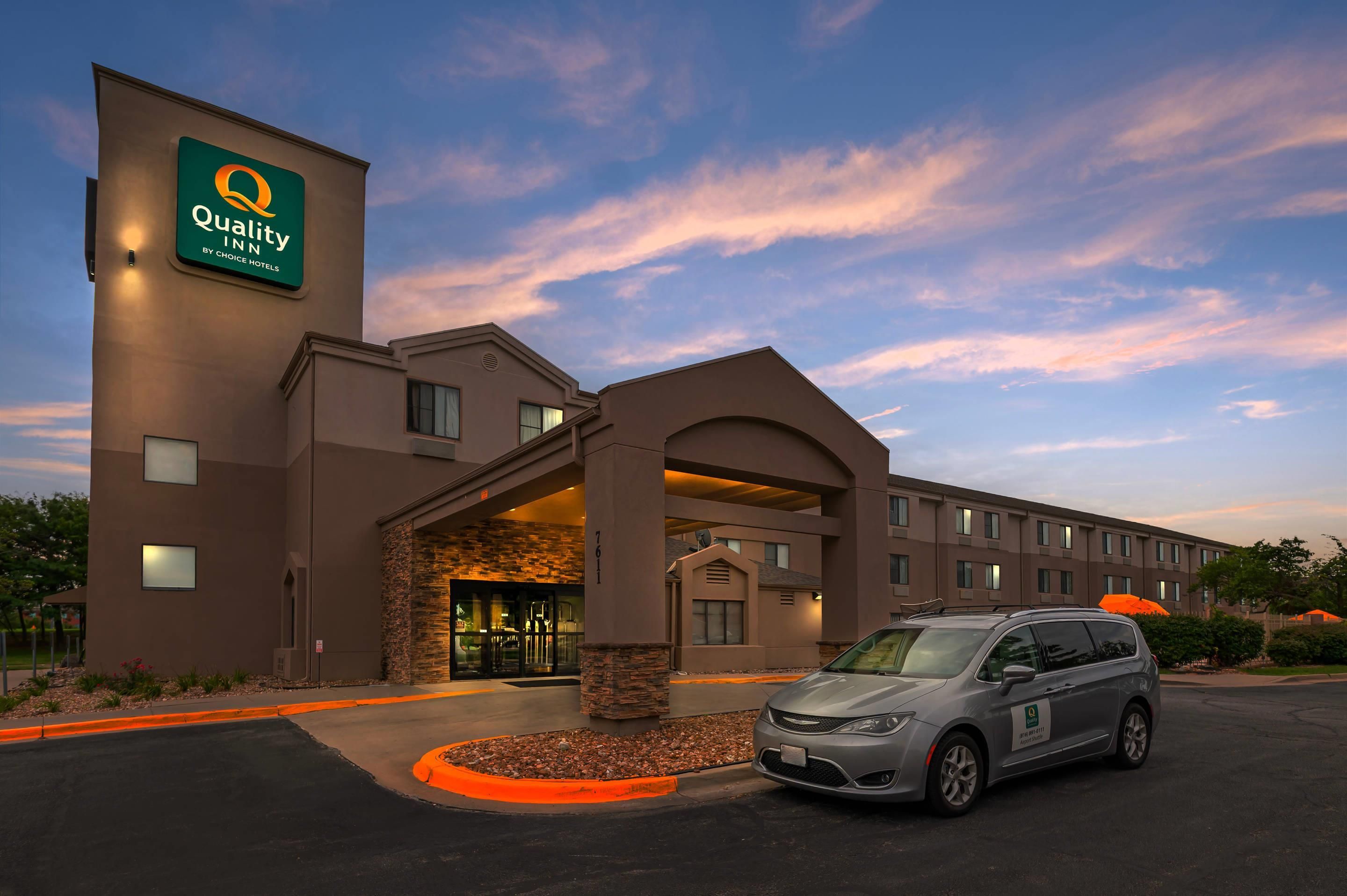A Quality Inn hotel with a modern design, featuring a prominent entrance and a parking area.