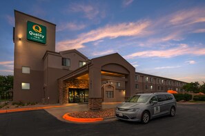 A Quality Inn hotel with a modern design, featuring a prominent entrance and a parking area. - Quality Inn Kansas City International Airport (Kansas City)