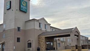 A Quality Inn hotel with a stone facade, multiple windows, and a covered entrance.