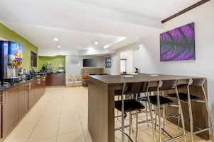 Una cocina moderna con barra, armarios de madera y una isla grande con taburetes.