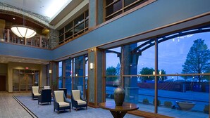A spacious lobby with a high ceiling, large windows, and a seating area with chairs. - Bally’s Evansville Casino & Hotel (Evansville)