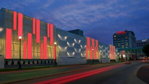 A modern building with large windows and vertical red panels, likely a hotel or commercial property.