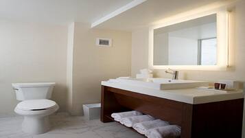 A modern bathroom with a toilet, a sink with a mirror, and a towel rack.