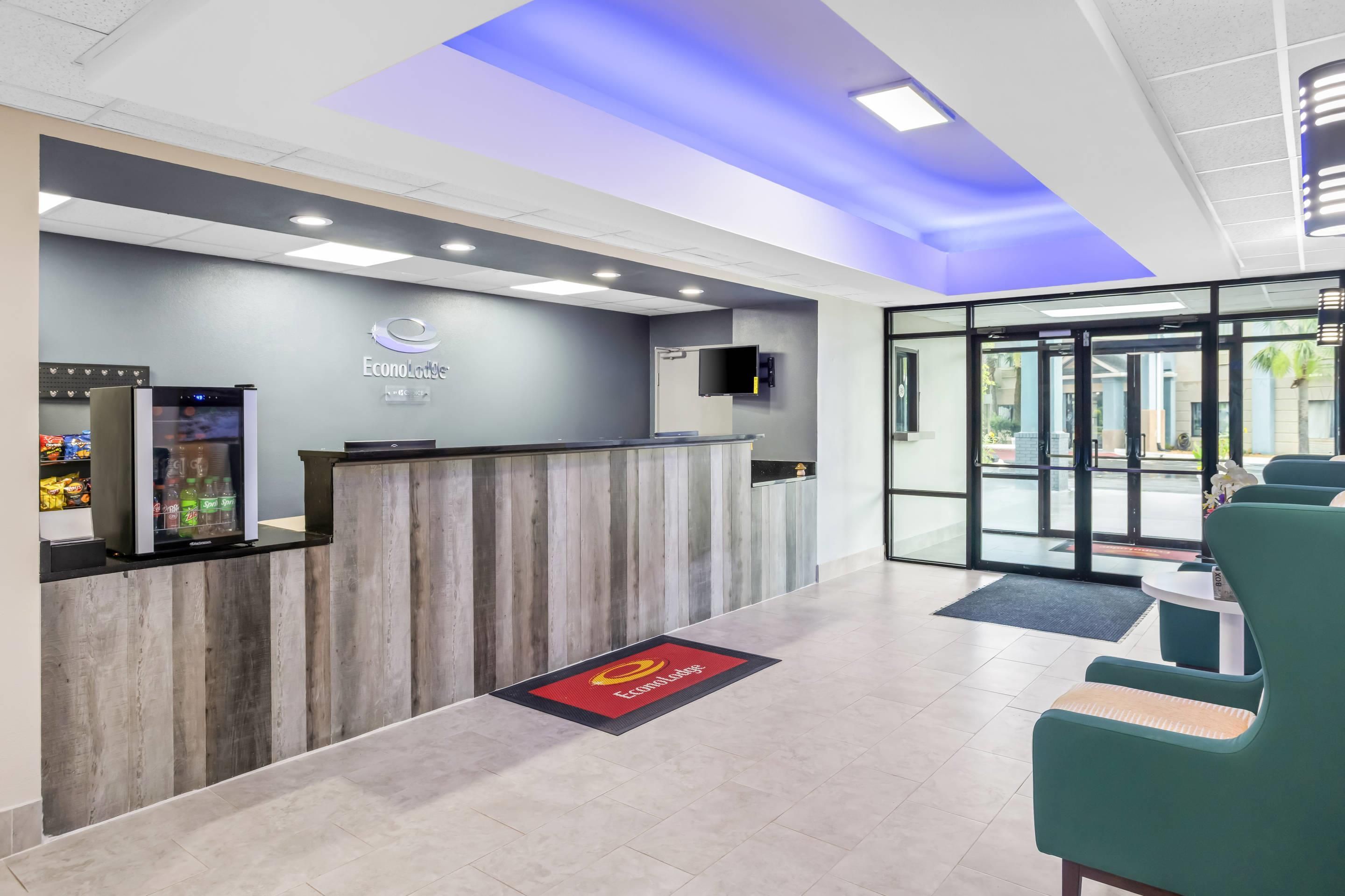 A reception area with a counter, seating, and a glass door entrance.