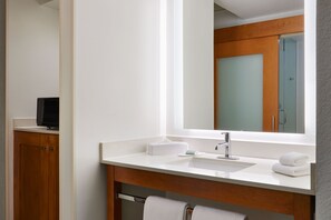 Une salle de bain moderne avec un lavabo blanc, un miroir et un meuble en bois.