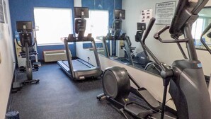 Ein Fitnessstudio mit Laufbändern, Crosstrainern und Gymbällen.