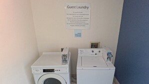 Een wasserette met twee Whirlpool wasmachines en een bord met wasinstructies.