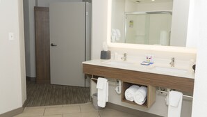 A modern bathroom with a large mirror, a sink, and a towel rack. - Holiday Inn Express Hotel & Suites Madison by IHG (Madison)