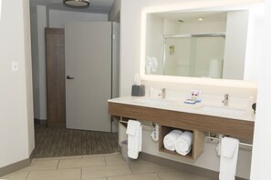 Un baño moderno con un espejo grande, un lavabo y un perchero para toallas.