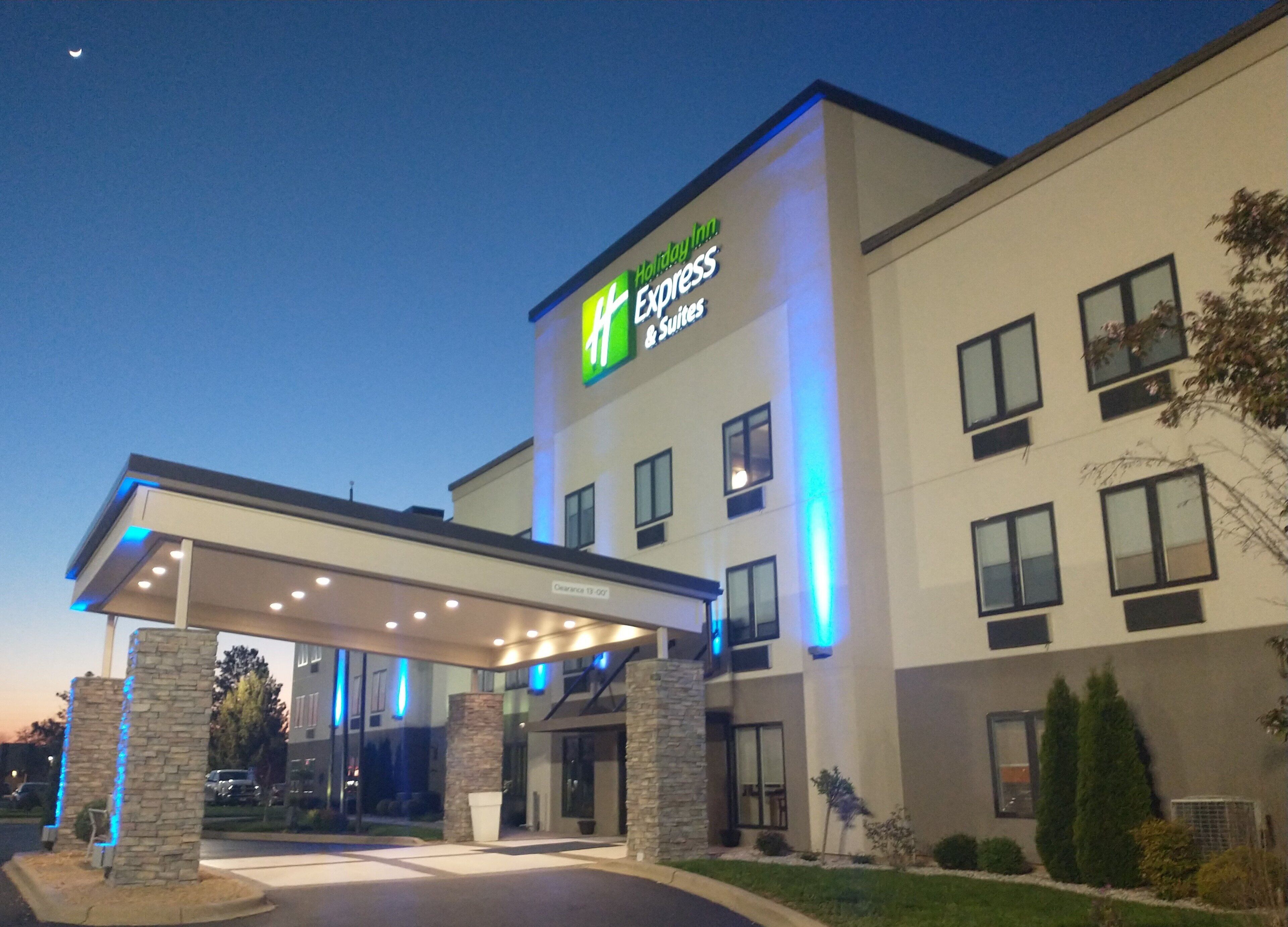 Un hotel Holiday Inn Express con una entrada techada y un cartel que indica 11 suites.