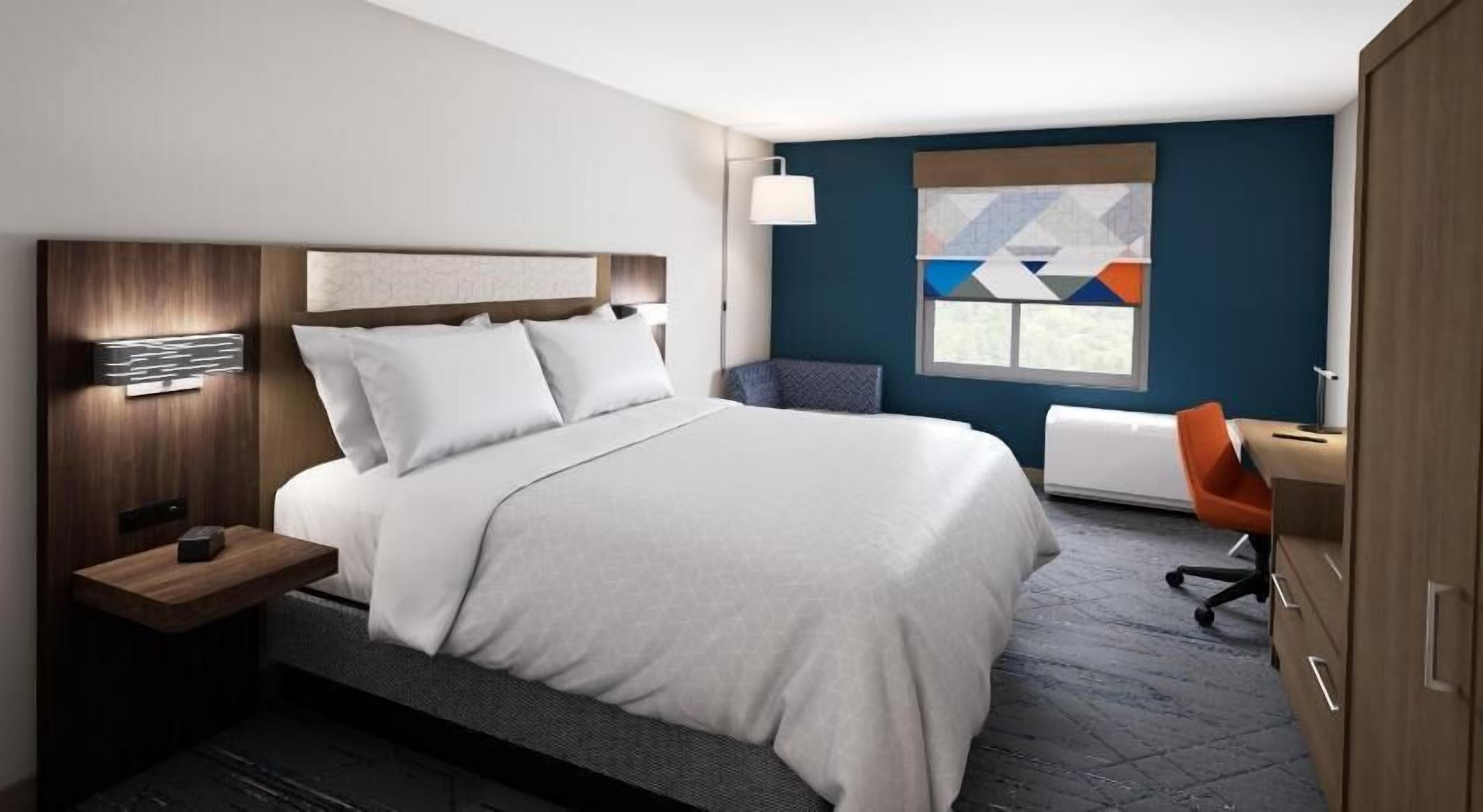 أغطية فراش متميزة وخزنة داخل الغرفة ومكتب ومساحة عمل للكمبيوتر المحمول