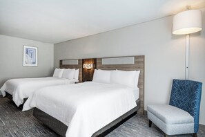 A hotel room with two beds, a nightstand, a lamp, and a chair. - Holiday Inn Express Rensselaer by IHG (Rensselaer)