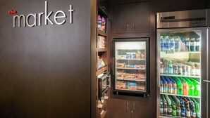 A vending machine area with snacks and drinks, a microwave, and a refrigerator stocked with beverages. - Courtyard by Marriott Stockton (Stockton)