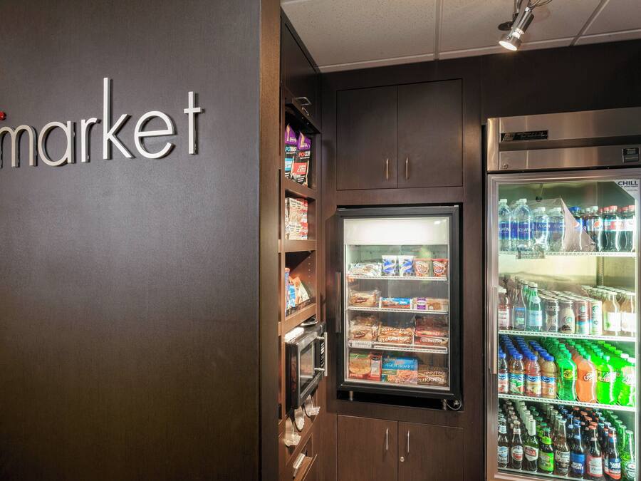 Un espace équipé d’un distributeur automatique de collations et de boissons, d’un four à micro-ondes et d’un réfrigérateur rempli de boissons.