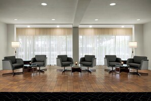 A hotel lobby with four armchairs, two side tables, and a coffee table. - Courtyard by Marriott Stockton (Stockton)