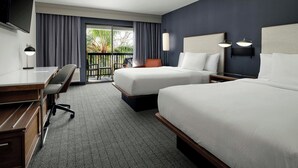 A hotel room with two beds, a desk, a chair, a TV, and a balcony with curtains. - Courtyard by Marriott Stockton (Stockton)