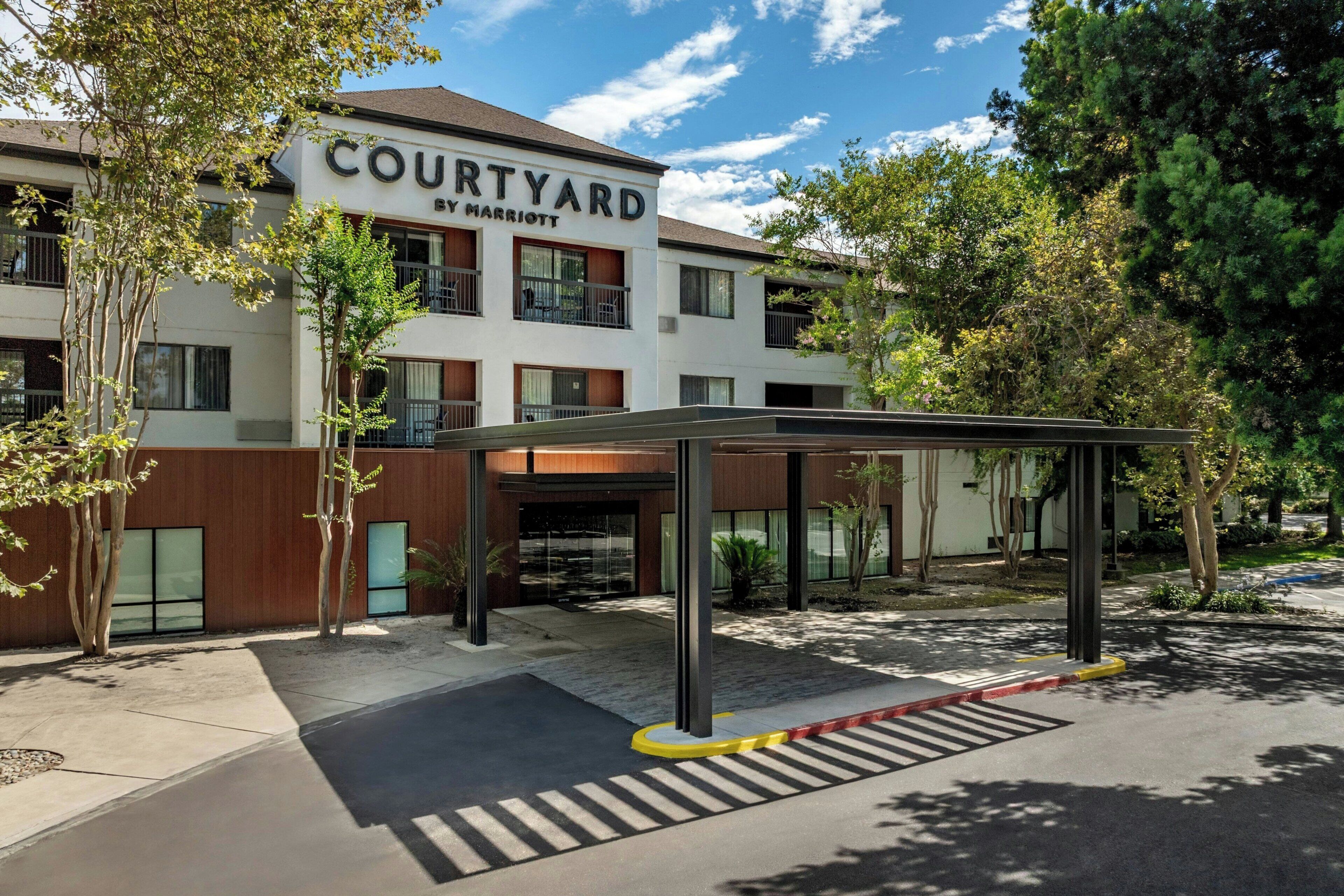 A Courtyard by Marriott hotel with a covered entrance and a parking area.