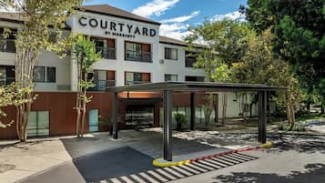 A Courtyard by Marriott hotel with a covered entrance and a parking area.