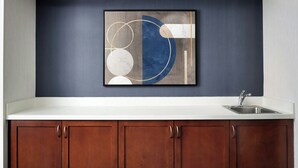A kitchen with a white countertop, a stainless steel sink, and wooden cabinets. - Courtyard by Marriott Stockton (Stockton)