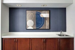 A kitchen with a white countertop, a stainless steel sink, and wooden cabinets. - Courtyard by Marriott Stockton (Stockton)
