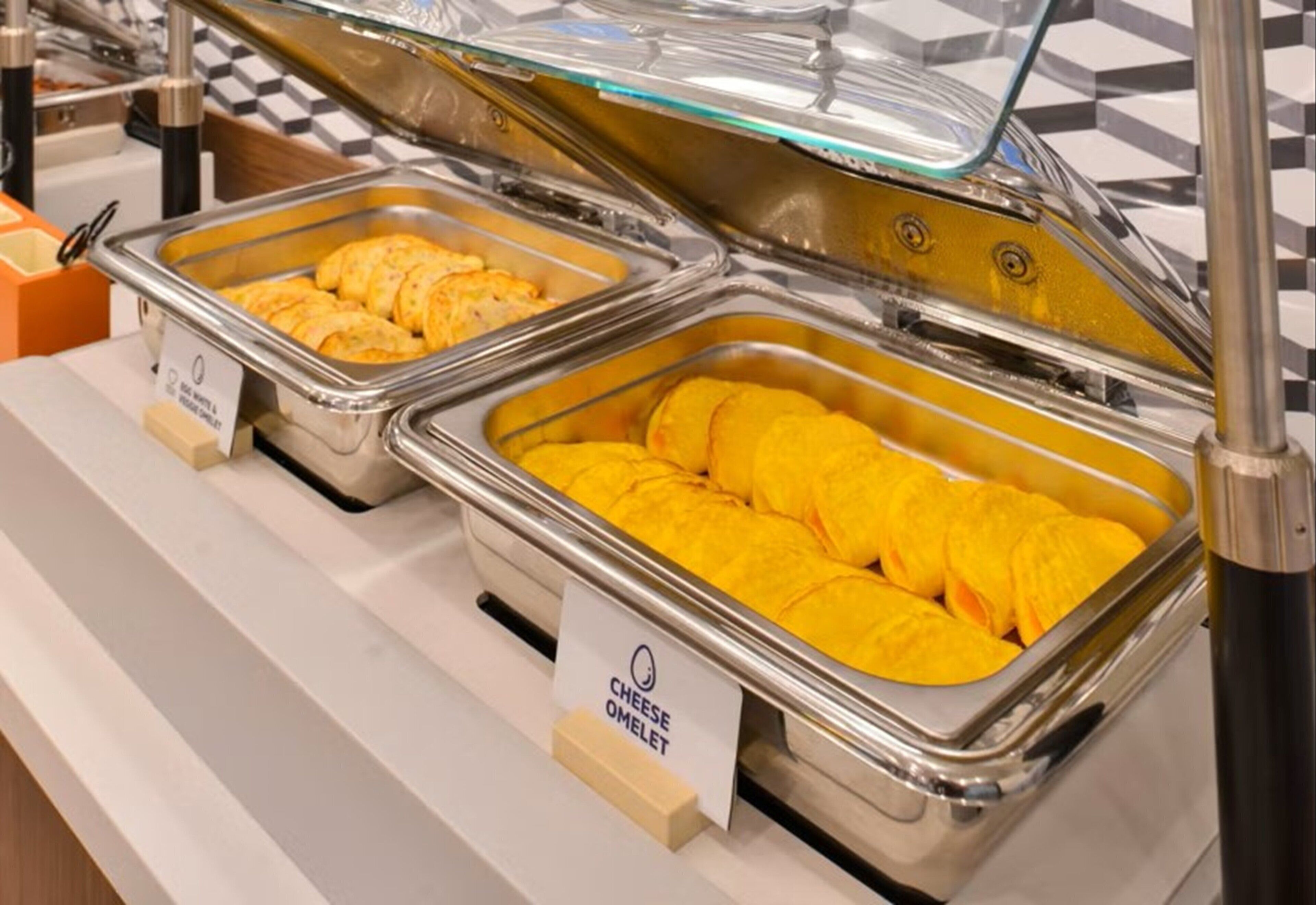 Ein Buffet mit beschrifteten Behältern für Omeletts und Käse.