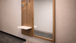 Ein modernes Badezimmer mit einem Holzboden, einem Spiegel und einer kleinen Ablage.