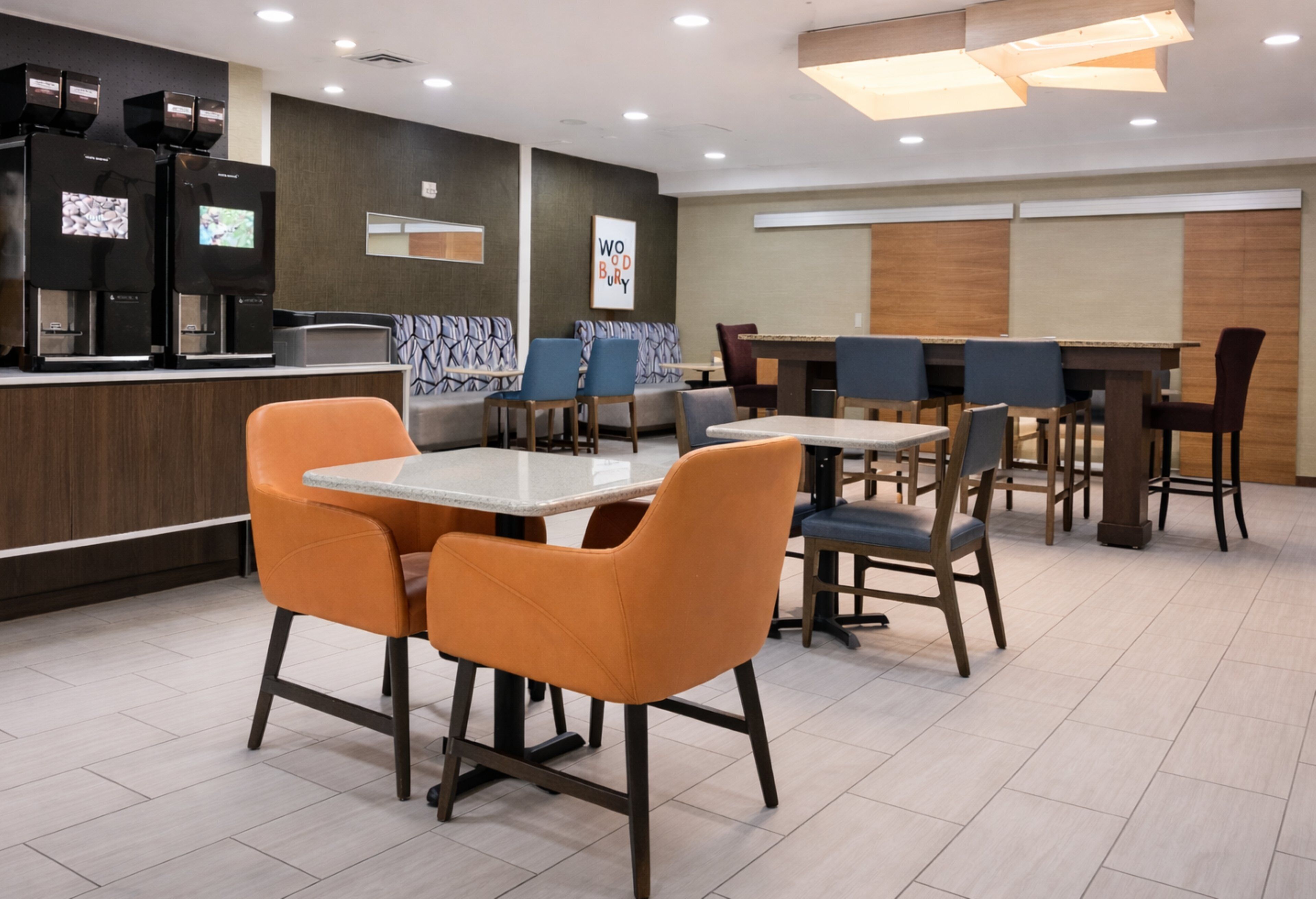 Un restaurant moderne doté d’un bar, de différents espaces pour s’asseoir et de machines à café.
