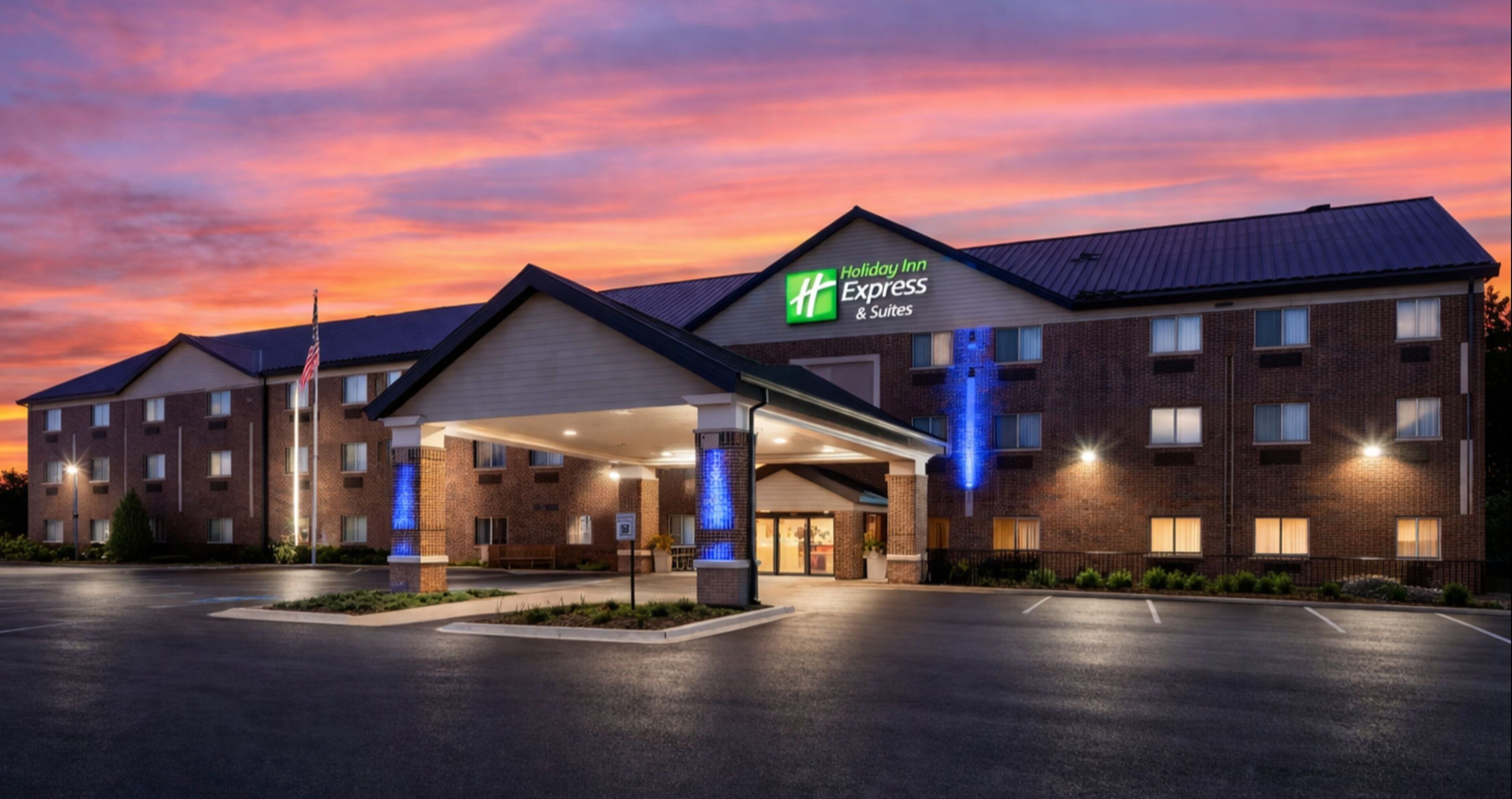 A Holiday Inn Express & Suites hotel with a brick facade, a covered entrance, and a parking lot.