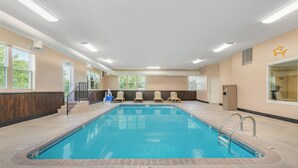 An indoor swimming pool with clear blue water, surrounded by beige walls and large windows. - Best Western Teal Lake Inn (Mexico)