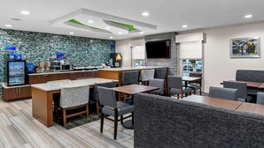 Un restaurante moderno con mostrador, zona de estar y una pantalla de televisión.
