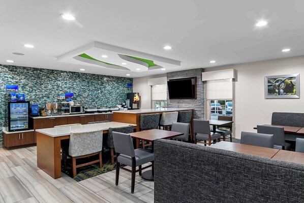 A modern restaurant with a counter, seating area, and a television screen. - Best Western Niceville - Eglin AFB Hotel (Niceville)