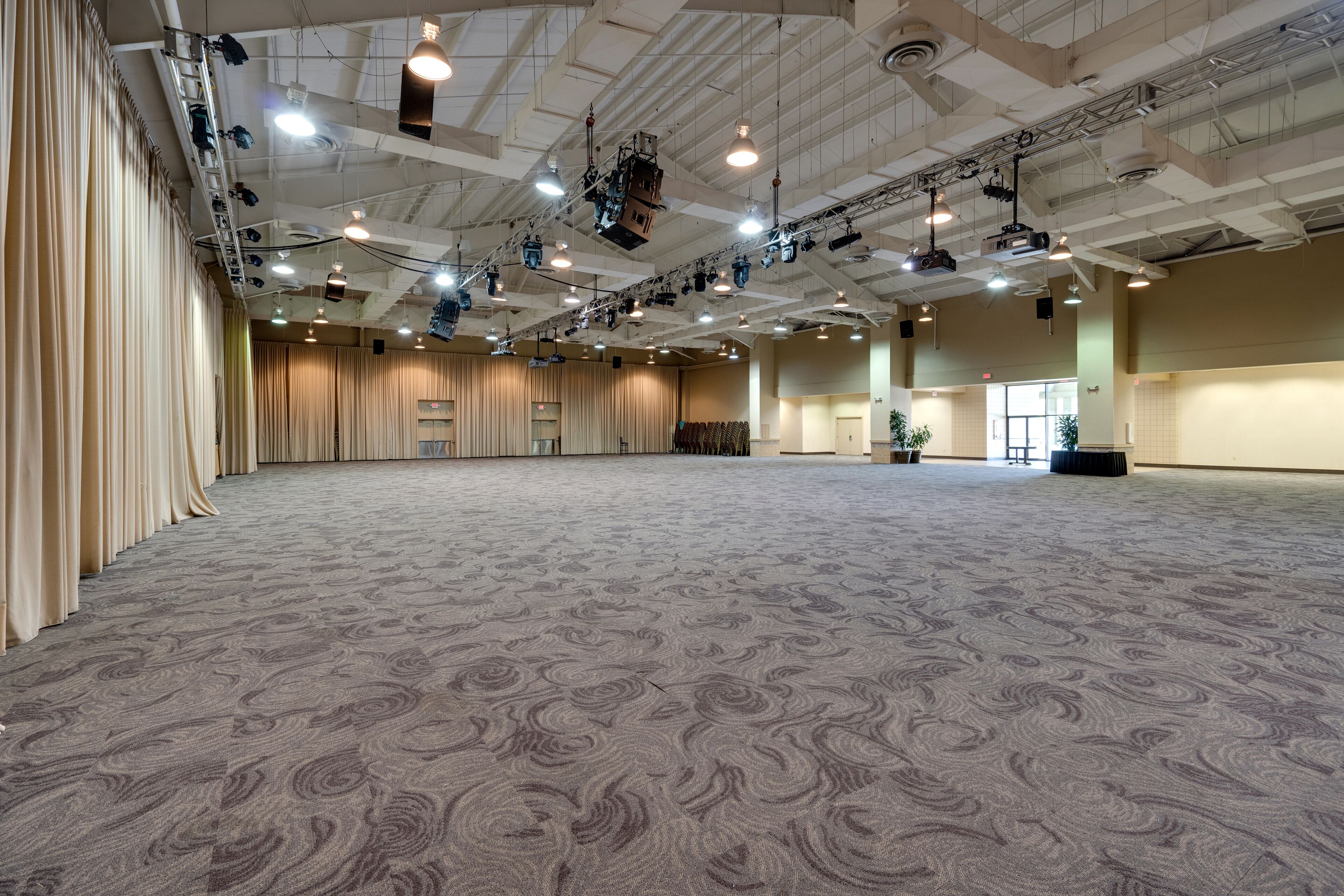 A large, carpeted hall with a high ceiling and multiple lighting fixtures.